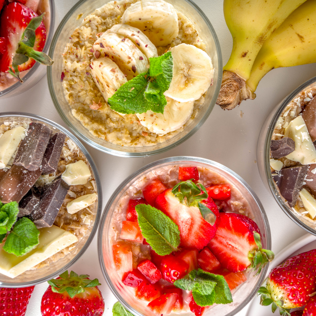 Colorful jars of overnight oats topped with fresh fruit, nuts, and seeds.
